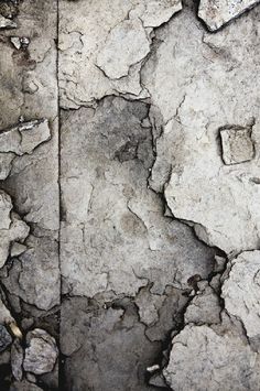 an old rock wall with cracks in it