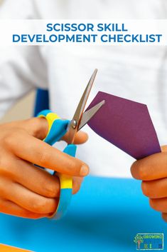 a person cutting paper with scissors on top of a blue table and the words scissor skill development checklist