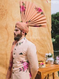 Designer Mens Sherwani in Peach Sherwani Style is all set to make a lasting impact in its unique style and print on men's sherwani. It will be your wedding outfit for sure if you are looking for an elegant and graceful Peach sherwani. Sherwani: Men Sherwani in Peach color is fully enhanced with floral prints on raw silk jamawar with Golden Engraved buttons. Pink Floral Print organza fabric High Rise turban is paired with floral men's sherwani. Trouser: The classic attire comes in with straight t Peach Sherwani, Men Sherwani, Mens Sherwani, Groom Wear, Organza Fabric, Pink Floral Print, Straight Trousers, Peach Color, Sherwani