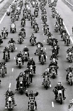 a large group of motorcyclists are riding down the highway