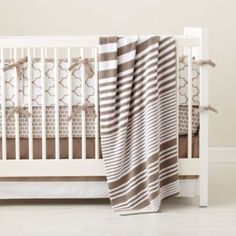 a white crib with a brown and white blanket