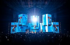 a group of people standing on top of a stage in front of a crowd at a concert