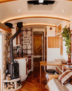 the interior of a small home with wood floors and white walls, including a stove