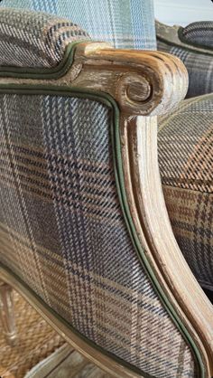 an upholstered chair with blue and brown checkered fabric on it's back