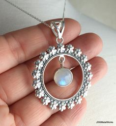 This beautiful floral solid sterling silver round pendant, with a dangling round labradorite or moonstone gemstone, is suspended on an 18 inch sterling silver 1mm cable chain. It is perfect for any occasion and is great for layering! Pendant height: 1.9 inches or 49mm, including bail Pendant width, at widest point: 1.5 inches or 38mm Dangling gemstone + silver setting diameter: 0.43 inches or 11mm Pendant setting and bail: sterling silver Convo me for a different length chain (additional charges Silver Labradorite Jewelry With Moon Charm, Round Labradorite Jewelry With Moon Charm, Labradorite Jewelry With Moon Charm, Silver Moonstone Round Pendant Jewelry, Moon Charm Labradorite Jewelry, Bohemian Jewelry With Round Pendant For Anniversary, Bohemian Round Moonstone Jewelry, Nickel Free Moonstone Necklaces, Bohemian Moonstone Round Pendant Jewelry