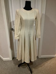 This nice vintage Vogue 50s 60s cream bone Pollyanna padded shoulder full romantic dress with huge bow in back comes to you in a size S-M. As you can see nice vintage cond. there are a couple of tiny pin prick holes one up by shoulder pictured and one on sleeve. Pretty typical age. Timeless flattering style. Waist is 14 inches across-21 1/2 inches shoulder to bottom of arm. 43 inches shoulder to bottom of dress. Full skirt style. Very figure flattering Fitted A-line Dress With Button Back, Cream A-line Winter Dress, Classic A-line Vintage Wedding Dress, 1950s Style A-line Midi Dress For Formal Occasions, Elegant Beige A-line Vintage Dress, Elegant A-line Midi Dress For Vintage Fashion, Beige A-line Midi Dress For Wedding, Fitted A-line Vintage Dress For Winter, Vintage Long Sleeve Beige Midi Dress