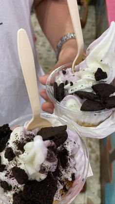 two desserts with ice cream and oreo cookies on top are being held by people