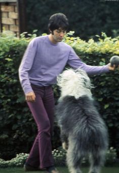 the man is walking his dog outside in the yard