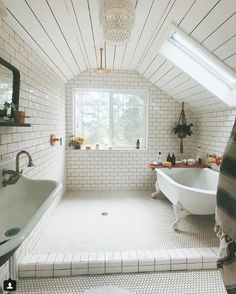 a bathroom with a tub, sink and window in it's roof dormer