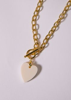 16" gold-filled link chain attached with dangling white bone heart. Heart-shaped White Chain Necklace For Gift, Everyday White Heart Necklace With Delicate Chain, White Heart Necklace With Chain, White Heart Pendant Charm Necklace With Adjustable Chain, White Heart Pendant Necklace With Adjustable Chain, Elegant White Heart Necklace With Chain, Chunky Chain White Necklace For Everyday Wear, White Chunky Chain Necklace For Everyday, Everyday White Chunky Chain Necklace