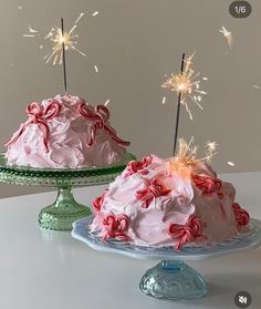 two cakes with pink frosting and candy canes on top