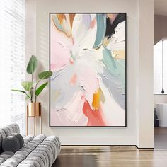 an abstract painting hangs on the wall next to a couch