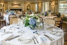 a table set with white and blue flowers, silverware, and napkins for an elegant wedding reception