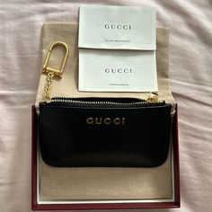 Brand New In Case Pouch And Red Gucci Box With Ribbon All Included. Price Firm This Zip Key Case, Featuring An Inside Hook, Appears In Black Leather And Sports The Gucci Script Detail Across The Front In Light Gold-Toned Hardware. Black Leather Light Gold-Toned Hardware Taffeta Lining Gucci Script Detail Inside Hook Zip Closure Weight: 0.14lbs Approximately 4.9"W X 2.7"H X 0.6"D Made In Italy Luxury Wallets With Gold-tone Hardware As Gift, Gucci Black Bag As Gift, Black Gucci Bag As Gift, Chic Black Gucci Wallet, Gucci Box, Gucci Brand, Box With Ribbon, Key Case, Gucci Black