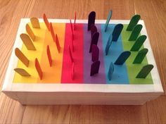 a box that has different colors of paper on top of it and scissors in the middle