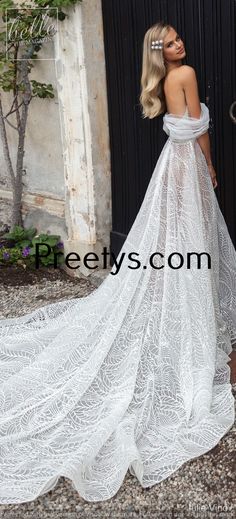 a woman in a white wedding dress is standing by a black door and posing for the camera