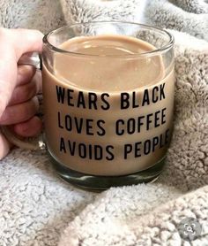 someone is holding a coffee mug that says, wears black loves coffee avoid people