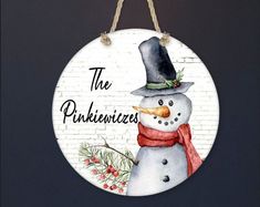 a snowman ornament hanging on a brick wall