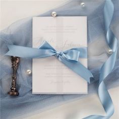 a wedding card with a blue ribbon tied around it and a key attached to it