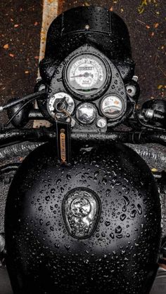 the motorcycle is parked on the side of the road covered in raindrops and water