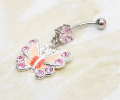 14g surgical steel belly ring with with pink crystal gem and matching pink enameled butterfly charm. Belly ring measures 1 7/8 inches long total length. Barbell is 14g standard surgical steel with a 10mm wearable bar length. Top ball measures 5mm, bottom ball measure 8mm. ** To keep the rhinestones looking their best I do not recommend you wear while swimming or bathing. For Belly Button Rings: https://www.etsy.com/shop/AllAboutClass?section_id=18474235&ref=shopsection_leftnav_1 All body jew Pink Dangle Belly Rings For Gift, Pink Dangle Belly Rings As Gift, Pink Stainless Steel Jewelry With Charms, Pink Dangle Jewelry With Butterfly Charm, Pink Butterfly Charm Dangle Jewelry, Adjustable Pink Body Jewelry For Gift, Pink Internally Threaded Belly Rings As Gift, Nickel-free Pink Belly Rings As Gift, Pink Metal Jewelry With Butterfly Charm