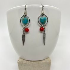 These look a little southwestern to me. I love turquoise, silver, and coral colors together. I grew up in South Dakota, so these remind me of home.  ♥ Materials used: - silver hoop earrings - turquoise magnesite heart beads - red coral howlite beads - silver feather charms ♥ CARING FOR YOUR JEWELRY Gently wipe your jewelry with a soft cloth to remove sweat, perfume, excess oils or dirt before putting them away. All of these products are handmade by me with care and attention to detail in a clean, smoke-free environment. I am happy to answer any questions you may have about any of my products. I also do custom orders, so please feel free to contact me with a design you have in mind. I will get back to you ASAP. Ships fast and free! Order today, ships next business day featuring USPS first c Handmade Bohemian Sterling Silver Heart Earrings, Bohemian Handmade Sterling Silver Heart Earrings, Bohemian Sterling Silver Heart Earrings, Handmade Heart-shaped Sterling Silver Hoop Earrings, Southwestern Dangle Hoop Earrings As Gift, Southwestern Style Dangle Hoop Earrings As Gift, Handmade Red Heart Earrings In Sterling Silver, Handmade Red Heart Sterling Silver Earrings, Nickel-free Red Southwestern Earrings