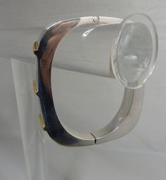 "Here's a stylishly modern hinged bangle bracelet, made in sterling silver and signed with Juan Sandoval Vazquez's Two Trees logo. It has gold vermeil accents on the front in a diagonal pattern, Interior circumference is 6.3/4\" and it is 3/8\" wide. It weighs 42 grams and is fully hallmarked. It is in exceptional pre-owned condition with no scratches or damage. Thanks for looking." Modern Metal Bangle With Polished Finish, Modern Sterling Silver Bangle Bracelet, Modern Bangle With Sterling Silver Clasp, Contemporary Formal Cuff Bracelet Bangle, Modern Silver Bangle With Polished Finish, Modern Metal Hinged Jewelry, Modern Polished Sterling Silver Bangle Bracelet, Modern Polished Sterling Silver Bracelet, Modern Polished Sterling Silver Bangle