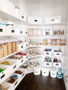 an organized pantry with white bins filled with food and containers full of cereal on the shelves