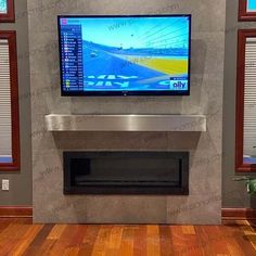 a flat screen tv mounted to the side of a wall next to a fire place