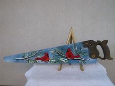 a pair of scissors sitting on top of a snow covered ski board with cardinals painted on it