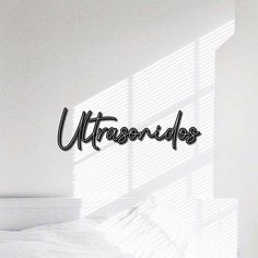 the word utensios written in cursive writing on a wall above a bed