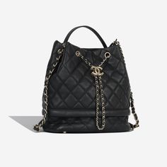 This quilted bucket bag from Chanel is effortlessly chic and edgy at the same time. If you're the kind of woman with a soft spot for Chanel, then it goes without saying that you need the brand's new It-bag. This bag is argued more practical, easy-going, and understated than the other Chanel classics, and is not here to dominate your outfit or draw too much attention to herself, its here to compliment and accentuate your look in the most tasteful way possible. SPL Exterior Black quilted caviar Champagne-gold tone hardware Interwoven chain / leather drawstring closure Leather top handle Chain / leather shoulder strap 2019 production Excellent condition - minor rubbing to corners, chain and edges / some slouch Interior Black textile lining Single compartment One slip pocket Excellent conditio Caviar Champagne, It Bag, Soft Spot, Black Caviar, Black Quilt, Easy Going, Luxe Fashion, Champagne Gold, Leather Chain