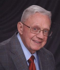 an older man wearing glasses and a suit