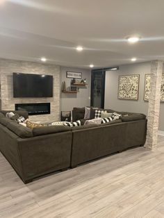 a living room filled with furniture and a flat screen tv mounted on the wall next to a fireplace