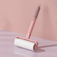 a pink and white electric toothbrush sitting on top of a table next to a wall