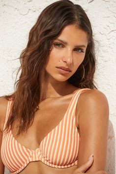 We couldn't imagine a more ideal summer day than something fun to sip on and the Rhythm Sunbather Orange Striped Underwire Bikini Top! Stretchy, ribbed tricot knit boasts a fun multicolored striped pattern throughout as it shapes supportive underwire cups, a scoop neckline, and adjustable straps. A shiny gold clasp secures at the back. Fit: This garment fits true to size. Length: Size medium measures 12.5" from top to bottom. Bust: Great for any cup size. Fabric: Fabric is very stretchy. Lined. Striped V-neck Swimwear For Beach, Beachwear Striped Swimwear, Bra Friendly, Bra Friendly Striped Beachwear Swimwear, Beachy Seamless Swimwear For Summer, Seamless Beachy Swimwear For Summer, Striped Bra-friendly Swimwear For The Beach, Striped Bra-friendly Beachwear Swimwear, Trendy Orange Swimwear For Summer, Seamless Beachwear For Summer