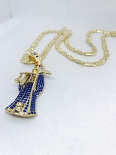 "Un dije mediano Santa Muerte 5.8cm diamantado con cristales azul cobalto alrededor del cuerpo en oro laminado y cadena medida a seleccionar 22\", 24\", o 26\" pulgadas; anchor de la cadena 5mm" Gold Crystal Pendant Jewelry, Blue Gold Plated Jewelry With Adjustable Chain, Blue Jewelry With Gold Chain For Gift, Blue Jewelry With Gold Chain As Gift, Blue Gold Chain Jewelry Gift, Gold Bling Pendant Jewelry, Gold Pendants For Men, Black Necklace, Gold Pendant