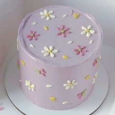 a pink cake with white and yellow flowers on it