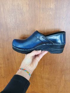 "Sanita (like Dansko clogs-maybe owned by same company?) Size 36 EU Us size 5.5/6 Blue with a splotchy black sponge over staining Nice used condition Danish the Original Danish Clog Clogs with back slip on  comfortable professional clogs leather Leather footbed 9.25\" insole   1 3/4\" heel" Blue Closed Toe Clogs With Leather Footbed, Blue Clogs With Leather Footbed And Round Toe, Blue Clogs With Wooden Heel And Round Toe, Blue Slip-on Clogs With Leather Sole, Blue Clogs With Leather Sole And Round Toe, Vintage Leather Footbed Clogs With Closed Toe, Blue Leather Sole Clogs With Round Toe, Vintage Leather Footbed Closed Toe Clogs, Blue Leather Closed Toe Clogs