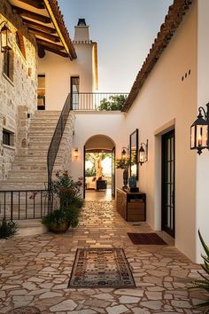 an entrance to a house with stone floors and steps leading up to the front door