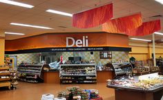 the inside of a deli with lots of food on display in front of it