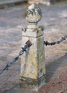 an old fence post with a chain attached to it