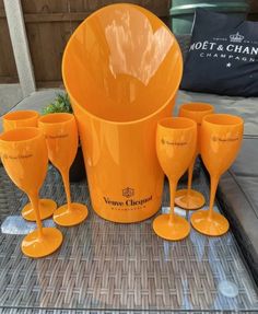 an assortment of orange wine glasses and cups