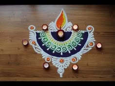 a decorated diya with candles on a wooden table