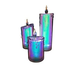 three purple and green candles sitting next to each other