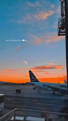 an airplane sitting on the tarmac at sunset