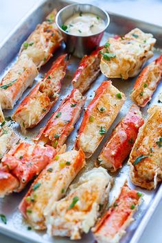 cooked lobsters on a tray with dipping sauce