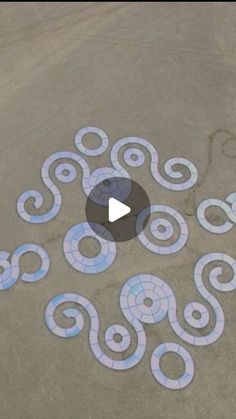 an artistic design is painted on the ground with white and blue circles around it,