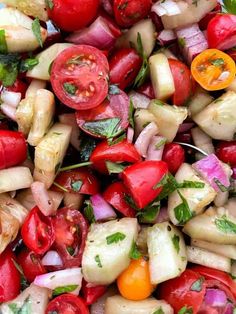 a salad with tomatoes, cucumbers, onions and other veggies in it