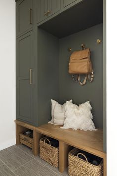 a wooden bench with two baskets and a purse hanging on the wall next to it